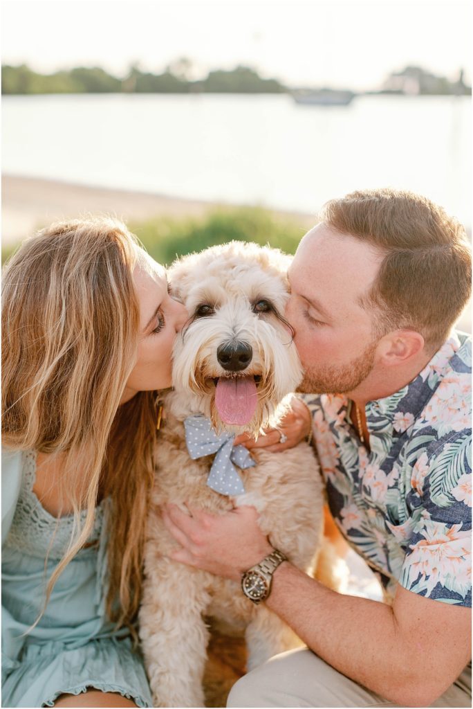 couple kissing dog on the cheek